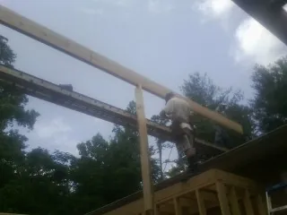 Carpenter setting a ridge beam over a new addition frame — Ice Dam Removal by Roofing Brothers in East Bridgewater