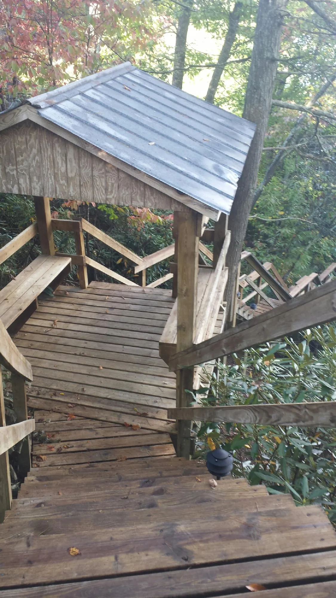 Metal roofed shelter over wooden steps on a wooded walkway — Skylight Repair & Installation work by our crew in East Bridgewater