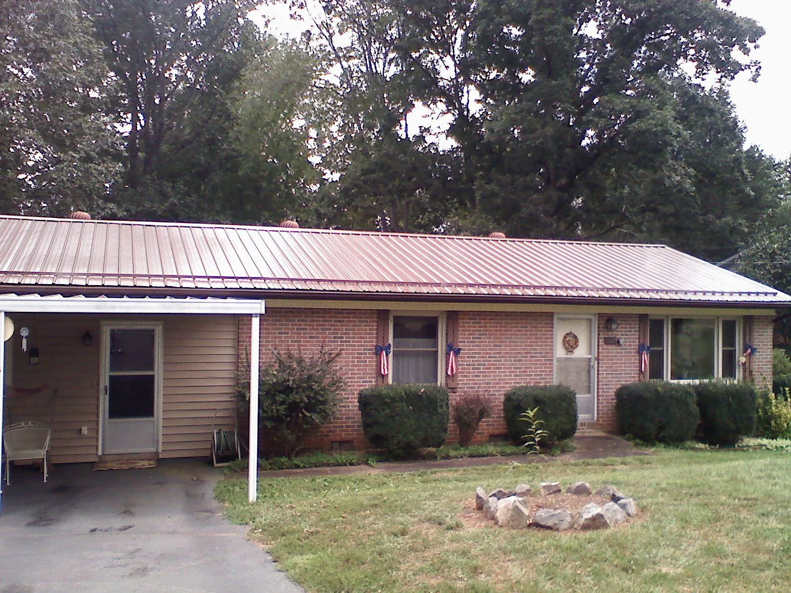 Bronze metal roof and carport on a brick ranch home — Roof Repair work by our crew in East Bridgewater